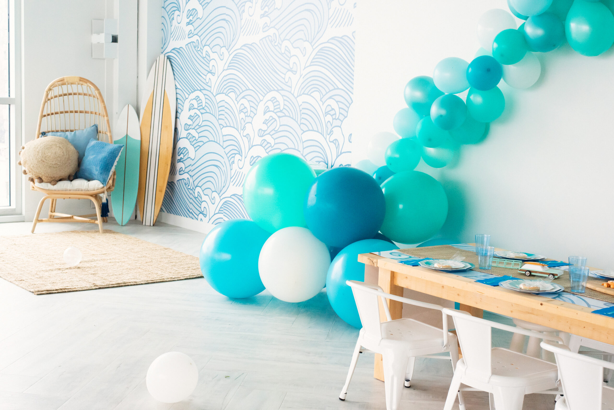 ocean birthday party with surf board and balloon arch